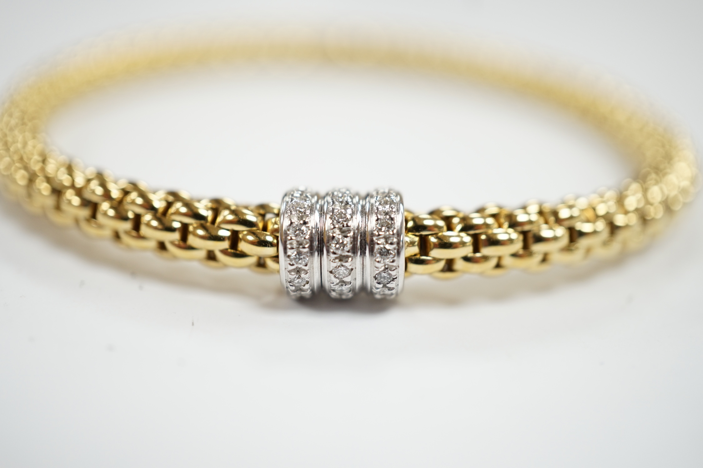 An Italian 18kt Fope flexible bracelet, with diamond chip set barrel shaped motif, gross weight 17.1 grams, with Fope box.